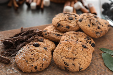 Delicious cookies with chocolate chips on wooden board, closeup