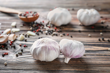 Fresh garlic with spices on wooden background