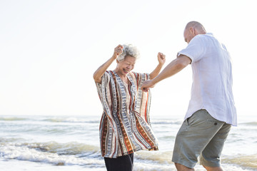 Mature mother and son dancing on the beach - obrazy, fototapety, plakaty