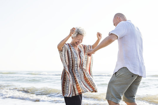 Mature mother and son dancing on the beach