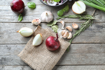Composition with onions and garlic on wooden background