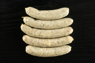 Group of five whole bavarian white sausage flatlay on black wood