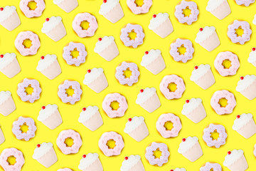 Sweets and desserts concept, donuts and cupcake cookies creative layout, simple pattern on trendy bright yellow background, above