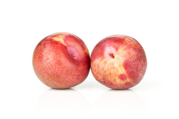 Group of two whole fresh pluot interspecific plums variety isolated on white