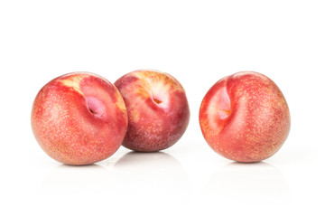 Group of three whole fresh pluot interspecific plums variety isolated on white