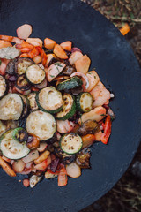 Cooking vegetables and food over an open fire on outdoor.