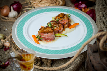 Medallions of meat with bacon.