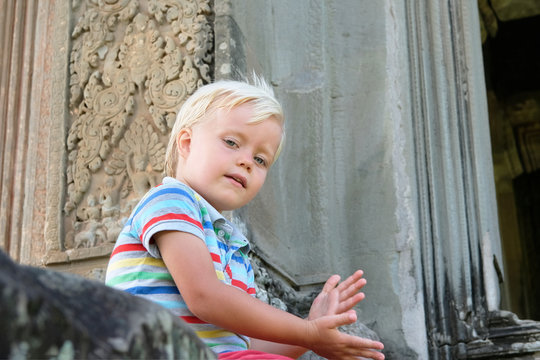 Cute little boy 4 years old blond hair sitting outdoor