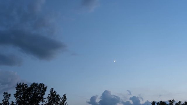 Scenic view of late evening sky with moon and clouds.