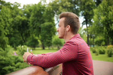Naklejka na ściany i meble Young man listening to music outdoors