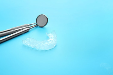 Dental instruments and occlusal splint on color background
