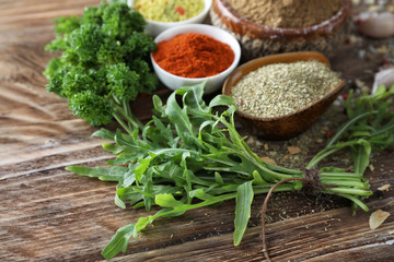 Various fresh herbs with dry spices on wooden table