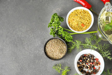 Various fresh herbs with dry spices on grey textured background