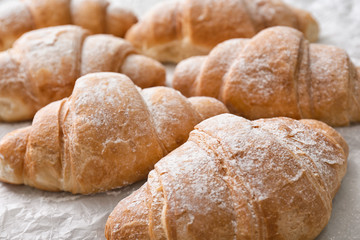 Tasty croissants on parchment, closeup