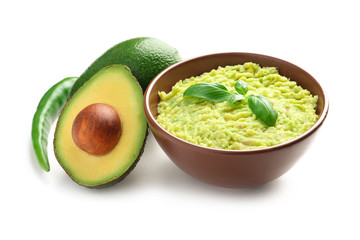 Bowl with tasty guacamole, chili pepper and ripe avocados on white background