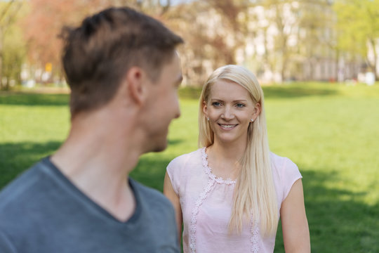 Young man turning to look at a pretty blond woman