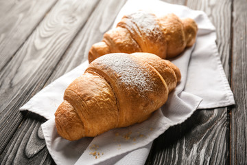 Tasty croissants on wooden background