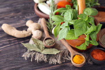 Various spices with herbs on wooden background