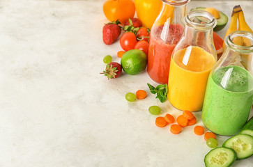 Bottles with fresh tasty smoothies and ingredients on table