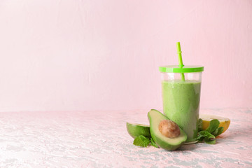 Glass of fresh avocado smoothie on table