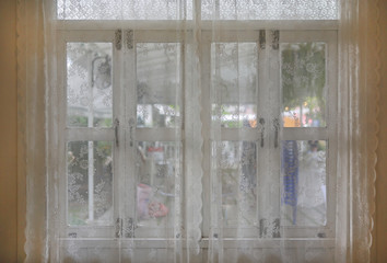 The lace curtain at a glass window.
