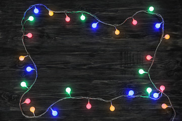 Glowing Christmas garland on wooden background