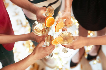 Young people clinking glasses at birthday party in club