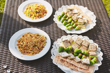 Variety of Indian sweet dish dessert made from bean on the weave wooden table