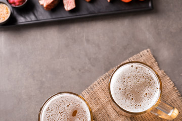 Mugs with fresh tasty beer on table