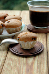 Muffins and a cup of coffee on a wooden background