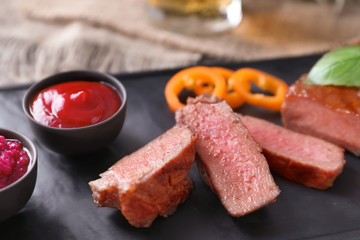 Plate with tasty grilled steak on table