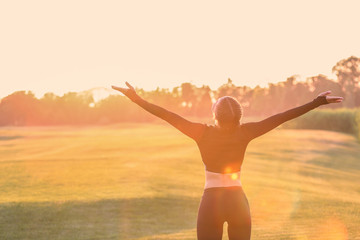 Athletic young woman enjoying nature at sunrise