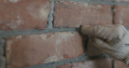 closeup of worker forming seam between bricks