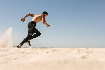 Man running on the beach - Powered by Adobe