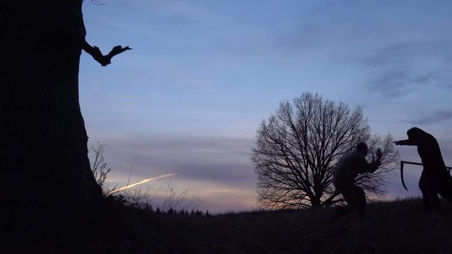 Grim Reaper came for a new victim and leads the victim to death. And the man begs for mercy. sunset silhouette. concept of death and the struggle for life