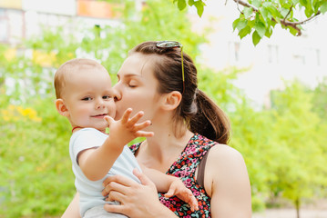 Cute cheerful child with mother play outdoors