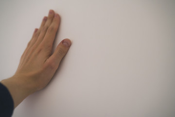closeup young man hand touching plastered wall