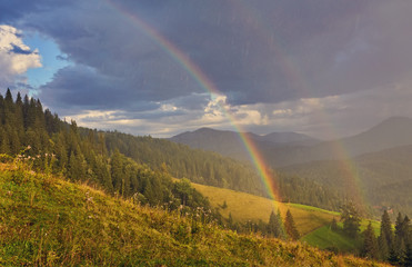 morning fog with red hot sunrise and rainbow in the mountains