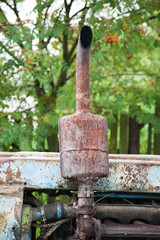 old rusty tractor exhaust pipe in the summer close-up
