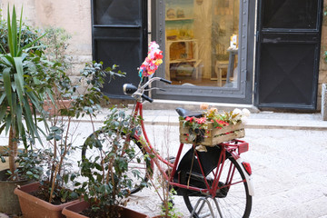 Fototapeta na wymiar Old bicycle with a box of flowers as a decoration on a city street