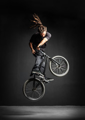 A man doing an extreme stunt on his BMX bicycle.