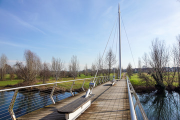 Pedestrian bridge across the river and nice reflection in water in sunny day