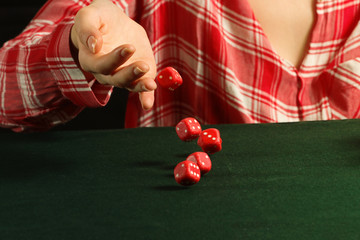 Girl rolling red dice fall on a table