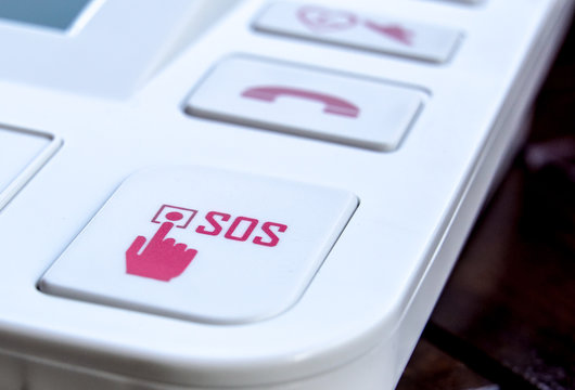sos Red button on a dirty old panel, selective focus