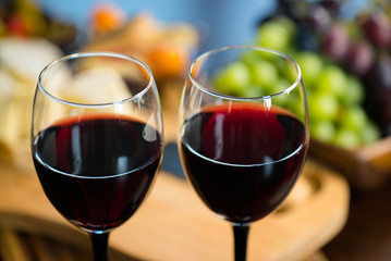Two glasses of wine on the background of various appetizers
