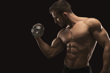 Fototapeta na wymiar Strong man with dumbbell showing muscular body