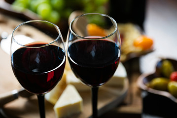 Two glasses of wine on the background of various appetizers