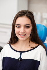 Face of a young woman with braces on her teeth . Healthy smile