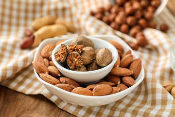 Bowls with different nuts on wooden table