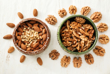 Composition with different nuts on white wooden background